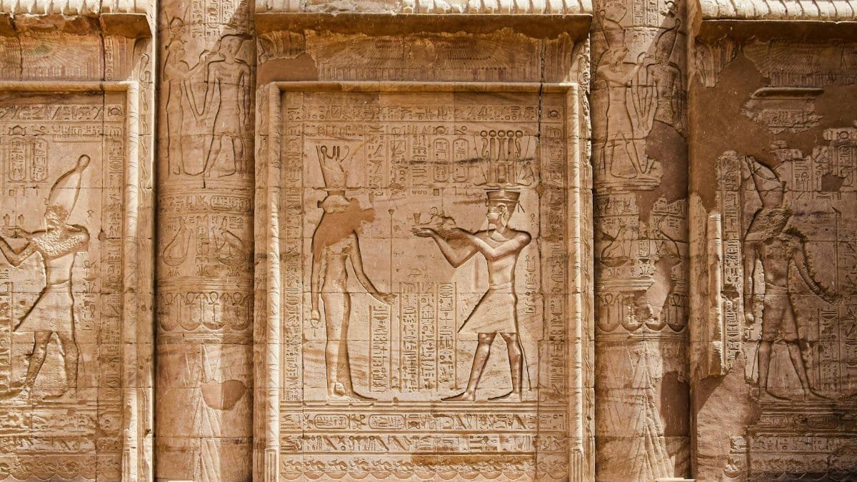 Engraved stone reliefs with intricate hieroglyphs from ancient Egyptian civilization.