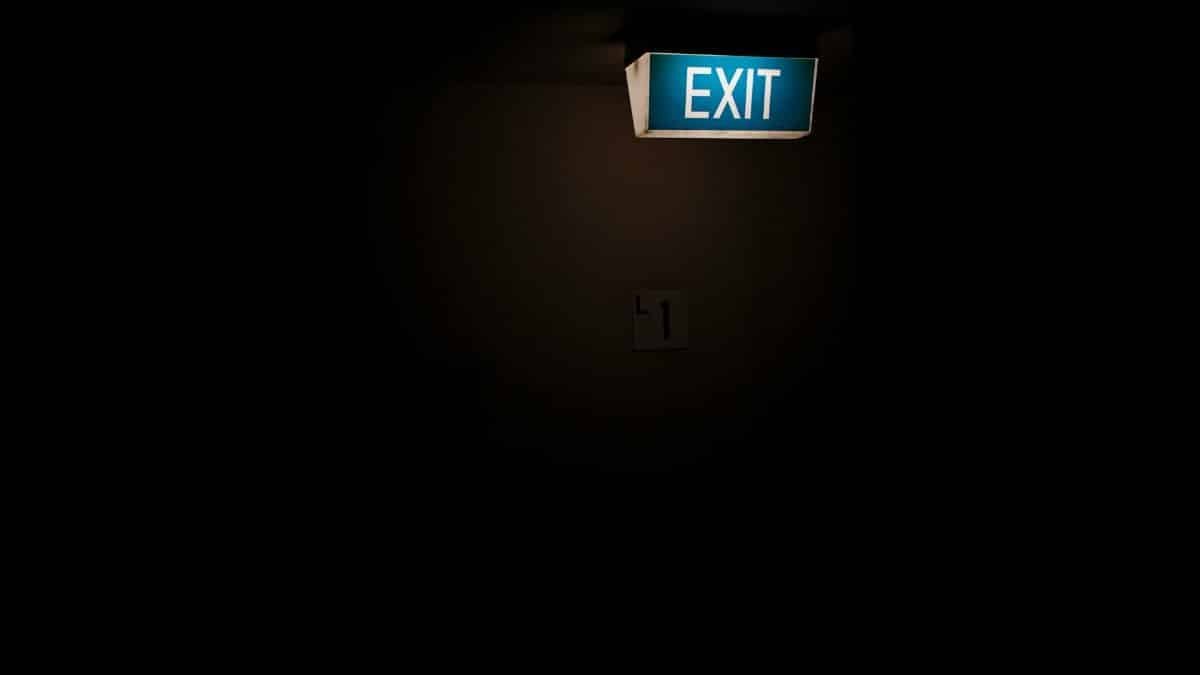 Dark interior space featuring a bright, illuminated exit sign for guidance.