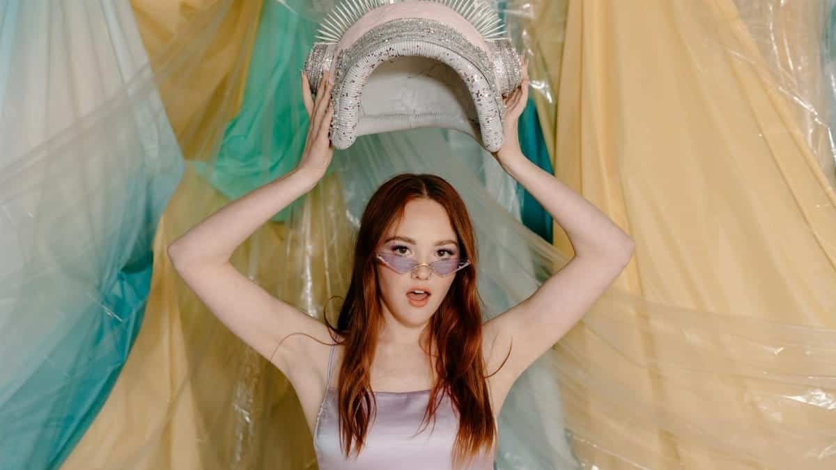 Stylish young woman in futuristic setting holding a cosmic themed accessory.