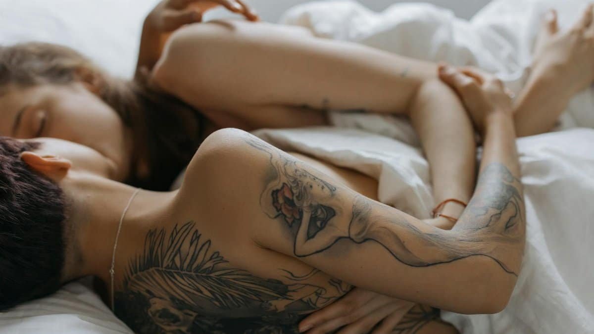 Two adults sharing a tender moment in a cozy bedroom, showcasing affection and relaxation.