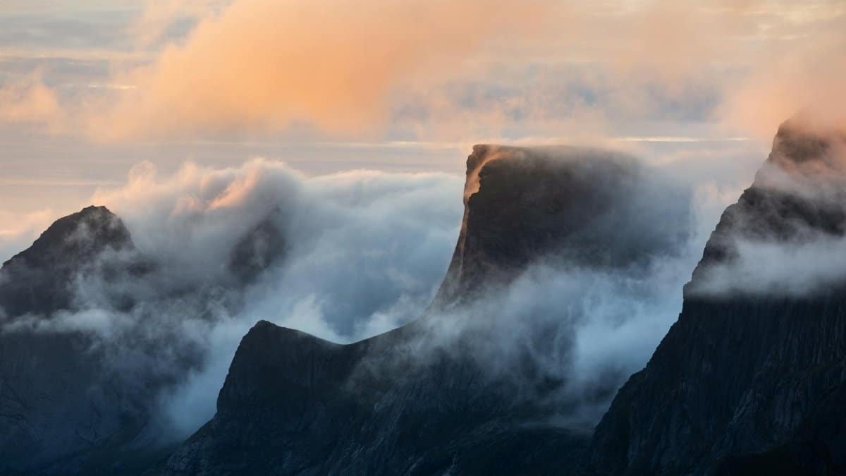 Ethereal sunrise over misty Norwegian mountains, capturing serene beauty and magical light.
