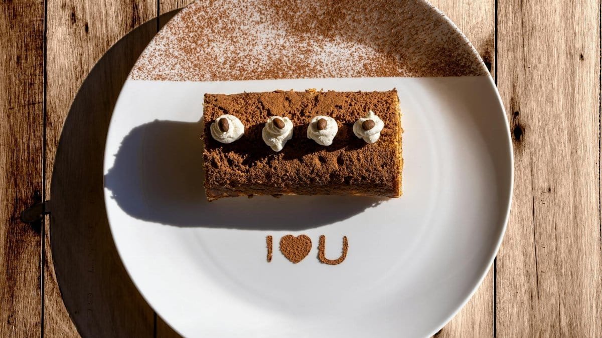 Delicious tiramisu with 'I ❤️ U' message on a sunlit plate, perfect for Valentine's Day.