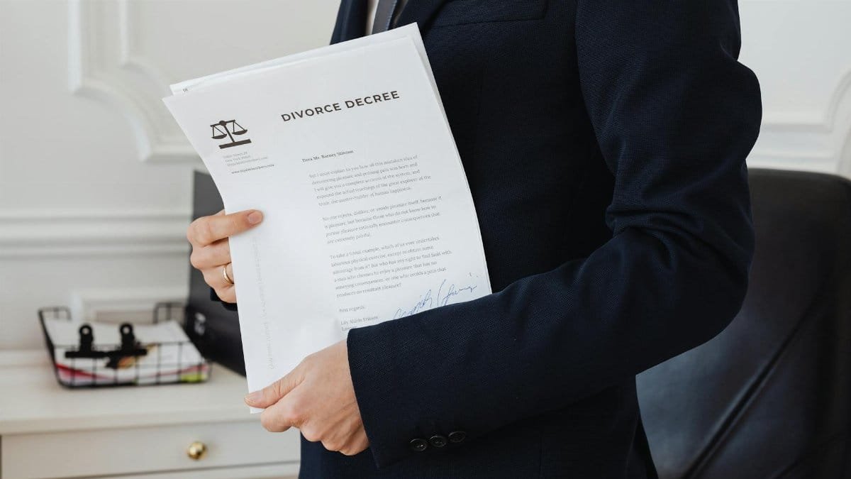 A person holding a divorce decree in an office setting, symbolizing legal proceedings.