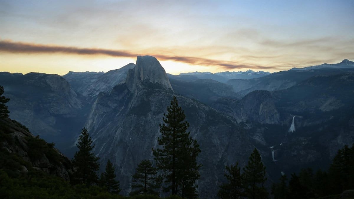 A stunning sunset view of Half Dome in Yosemite National Park, showcasing natural beauty and majestic landscapes.