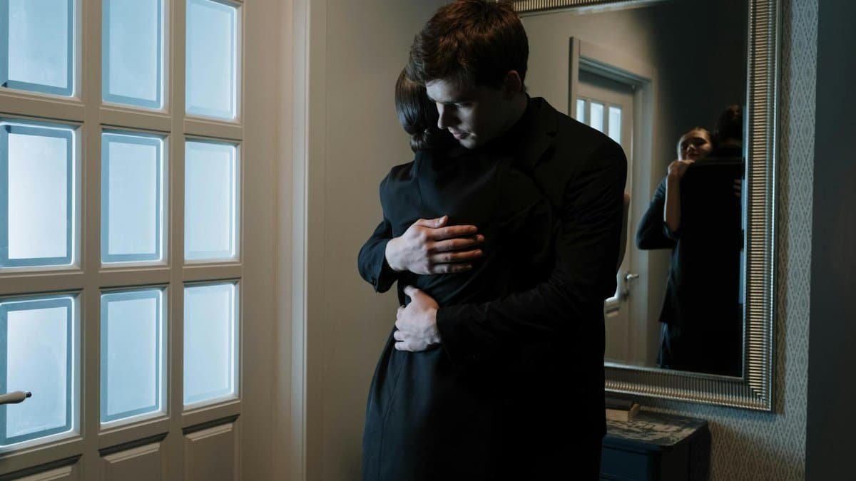 A couple shares an emotional embrace indoors, reflecting intimacy and support.