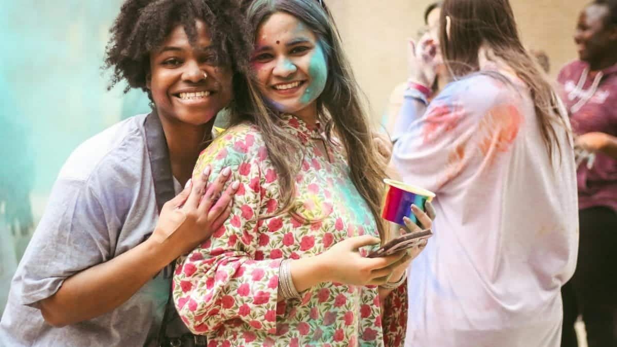 Friends enjoying a vibrant festival with colors and laughter, capturing joyful moments.
