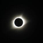 Captivating image of a total solar eclipse showcasing the sun's corona in the dark sky.