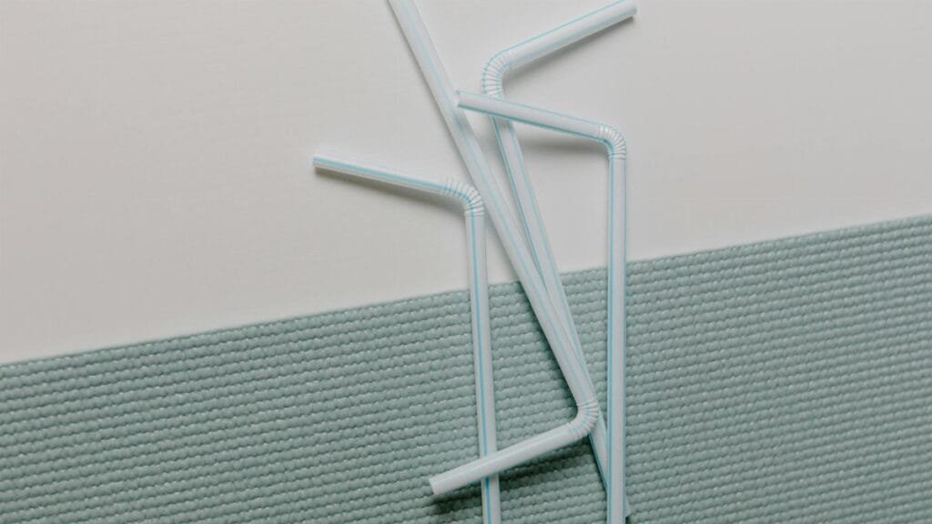 A modern close-up of plastic straws artistically arranged on a textured surface, ideal for design concepts.
