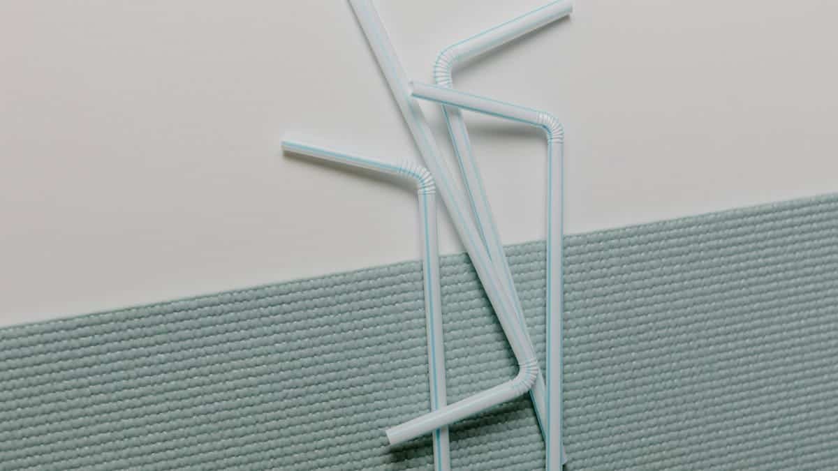 A modern close-up of plastic straws artistically arranged on a textured surface, ideal for design concepts.
