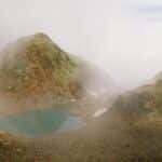 A serene misty mountain scene with a tranquil lake surrounded by rocky terrain in Spain.