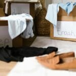 Decluttering concept using labeled boxes for sorting clothes in a home setting.