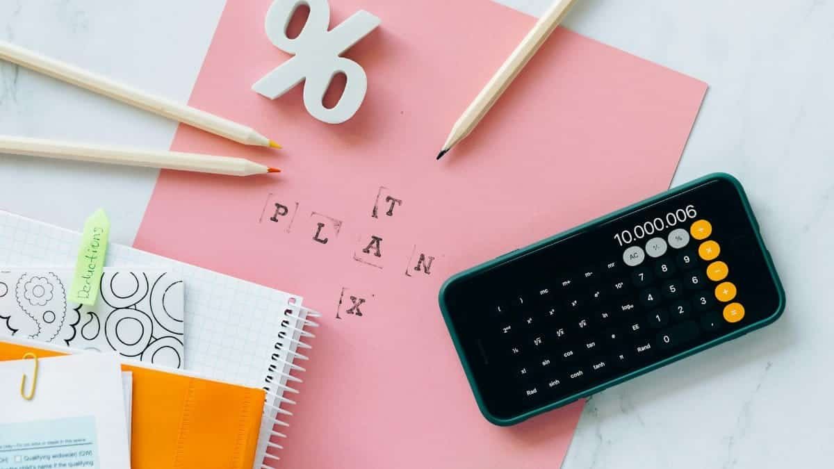 Flat lay showing tax planning tools including a calculator, pencils, and stationery items.
