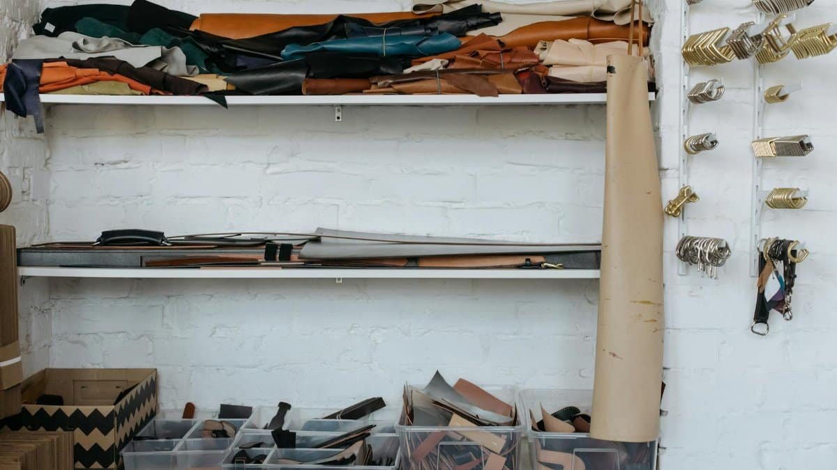 Organized leather crafts materials on shelves in a contemporary workshop setting.
