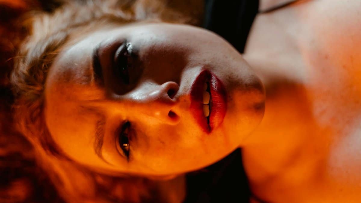 Close-up portrait of a woman with dramatic lighting, depicting intense emotion.