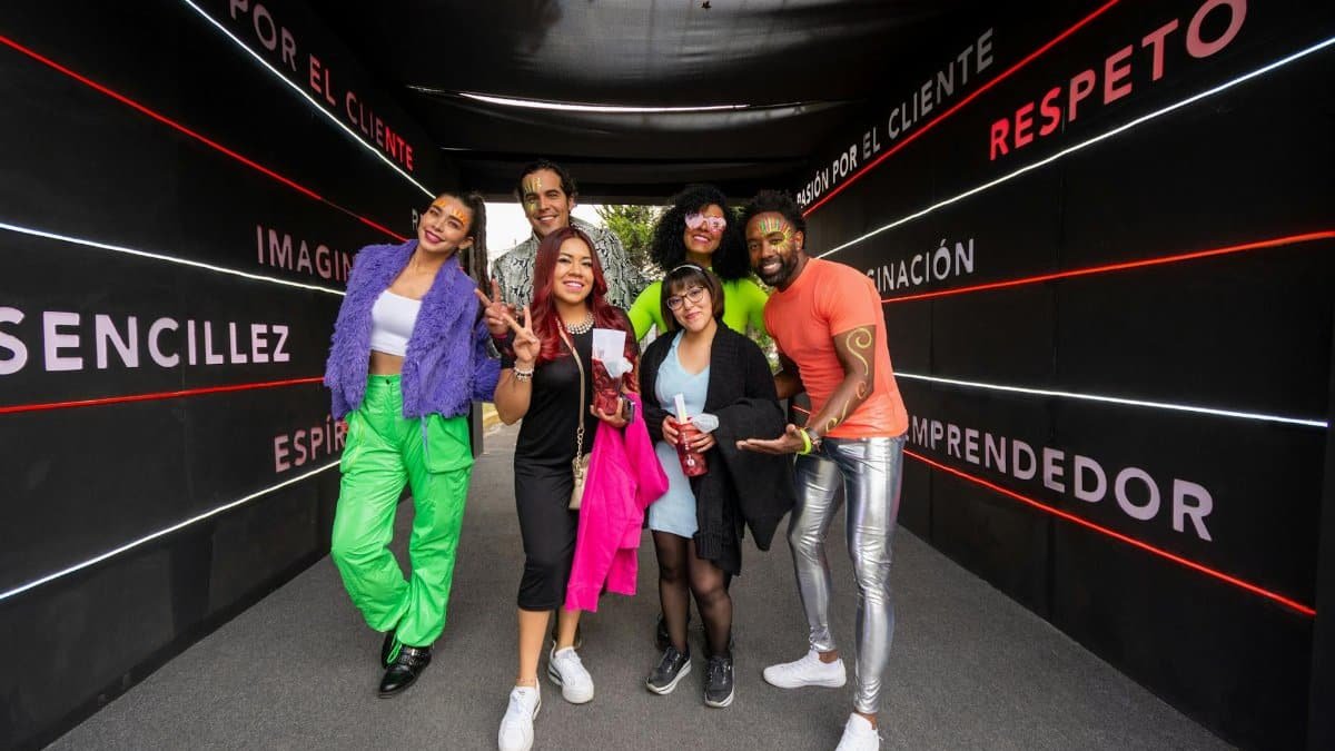 A joyful group celebrating in a colorful, festive tunnel in Mexico City.
