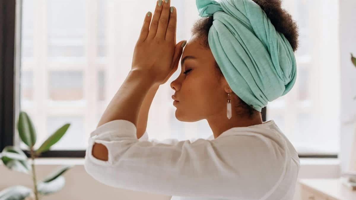 Woman practicing meditation indoors with a focus on relaxation and mindfulness.