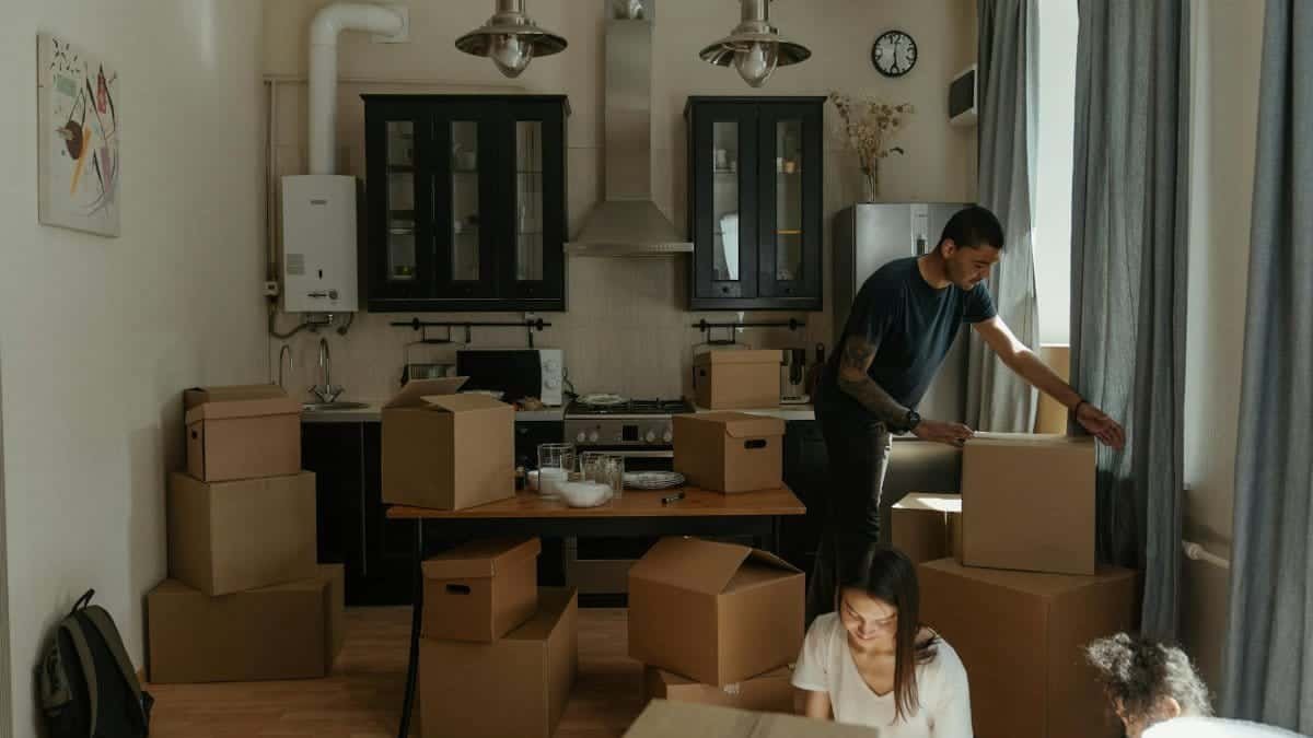 Family unpacking boxes in a cozy kitchen during home relocation.