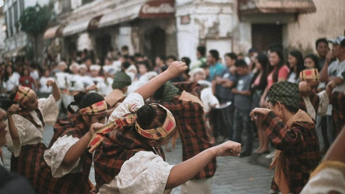 Vibrant street festival showcasing traditional dancers in cultural attire, captivating a diverse crowd.