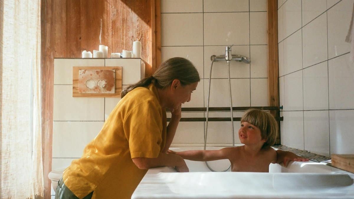 A warm moment between a grandmother and grandchild during bath time in a cozy bathroom.