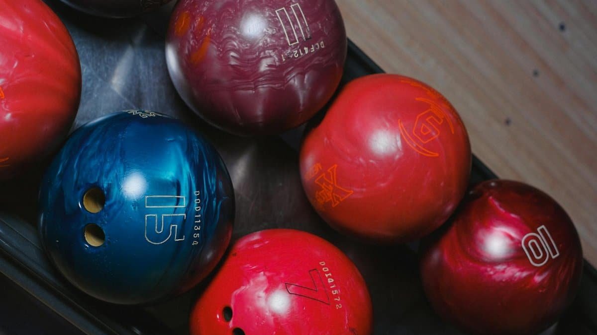 Close-up of colorful bowling balls in a rack, capturing leisure and fun.