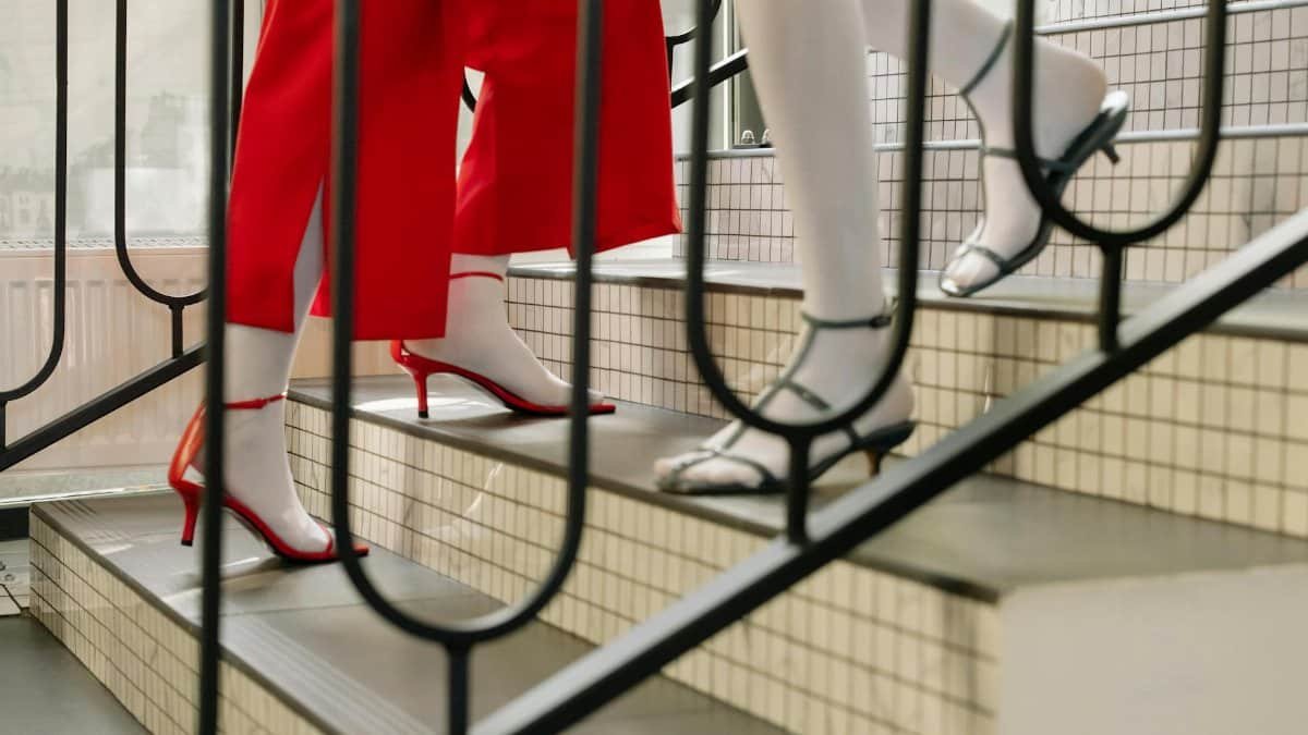 Stylish high heels worn by adults ascending a staircase.