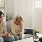 Emotional family therapy session with a therapist indoors, conveying connection and support.