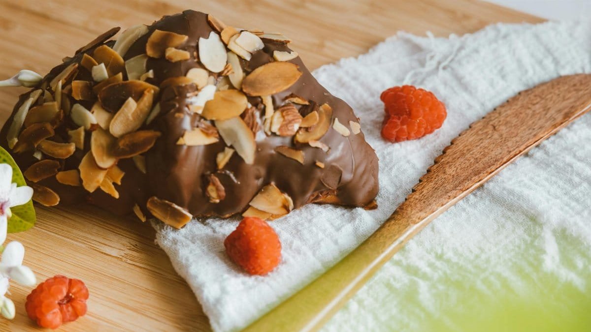 Indulge in a sweet treat with this chocolate almond croissant topped with fresh raspberries.