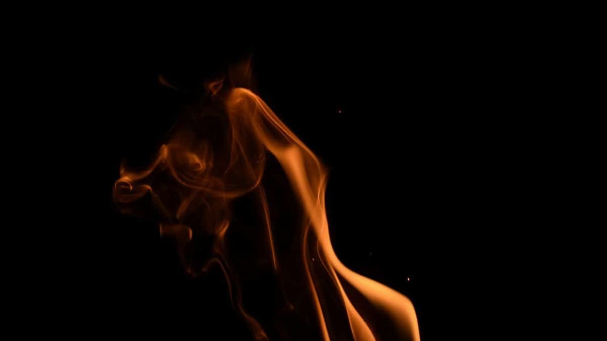 A captivating capture of an orange flame against a dark background, creating a dramatic and artistic effect.