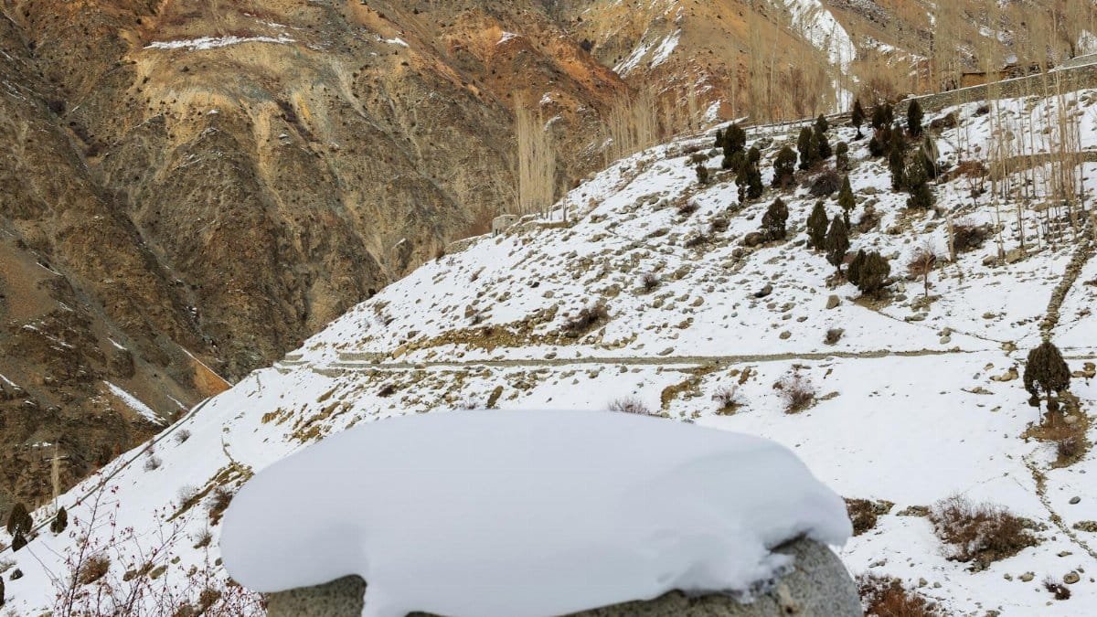 Serene view of snow-covered mountains with rocky terrain in a crisp winter setting.