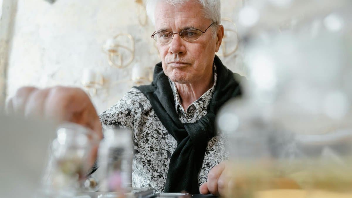 Elderly man exploring scents and aromas for aromatherapy indoors.