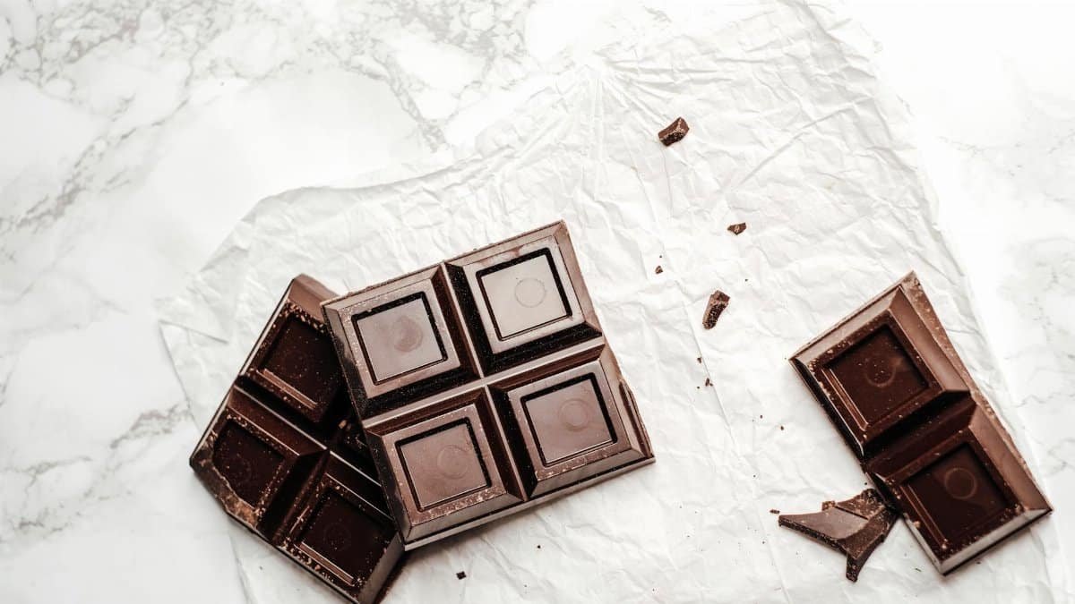 Elegant display of dark chocolate bars on a white marble surface. Perfect for dessert lovers.