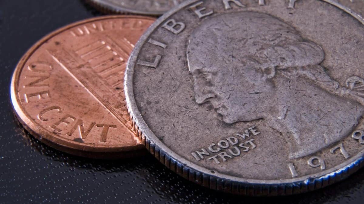 Detailed close-up of a US quarter and penny highlighting currency texture.
