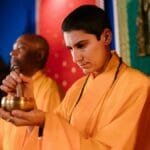 Buddhist monks meditating with a Tibetan singing bowl during a traditional ceremony.
