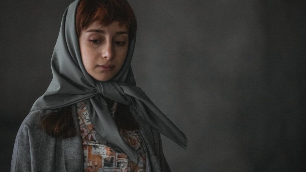 Portrait of a woman with a headscarf, exuding a contemplative mood.