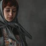Portrait of a woman with a headscarf, exuding a contemplative mood.