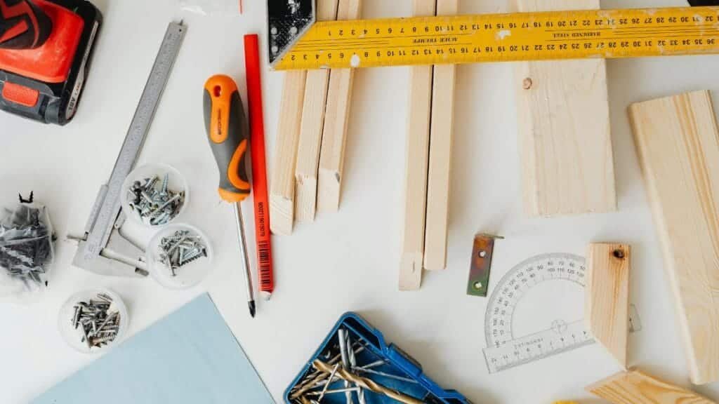 Top view of carpentry tools and wooden planks neatly arranged for a project.