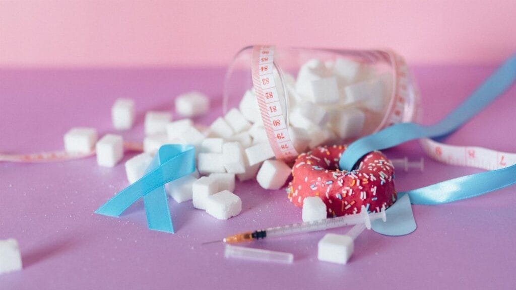 Pink and blue theme on diabetes awareness with sugar cubes and medical ribbons.
