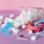 Pink and blue theme on diabetes awareness with sugar cubes and medical ribbons.