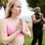 A group of senior adults practicing yoga in a serene park setting, promoting wellness.