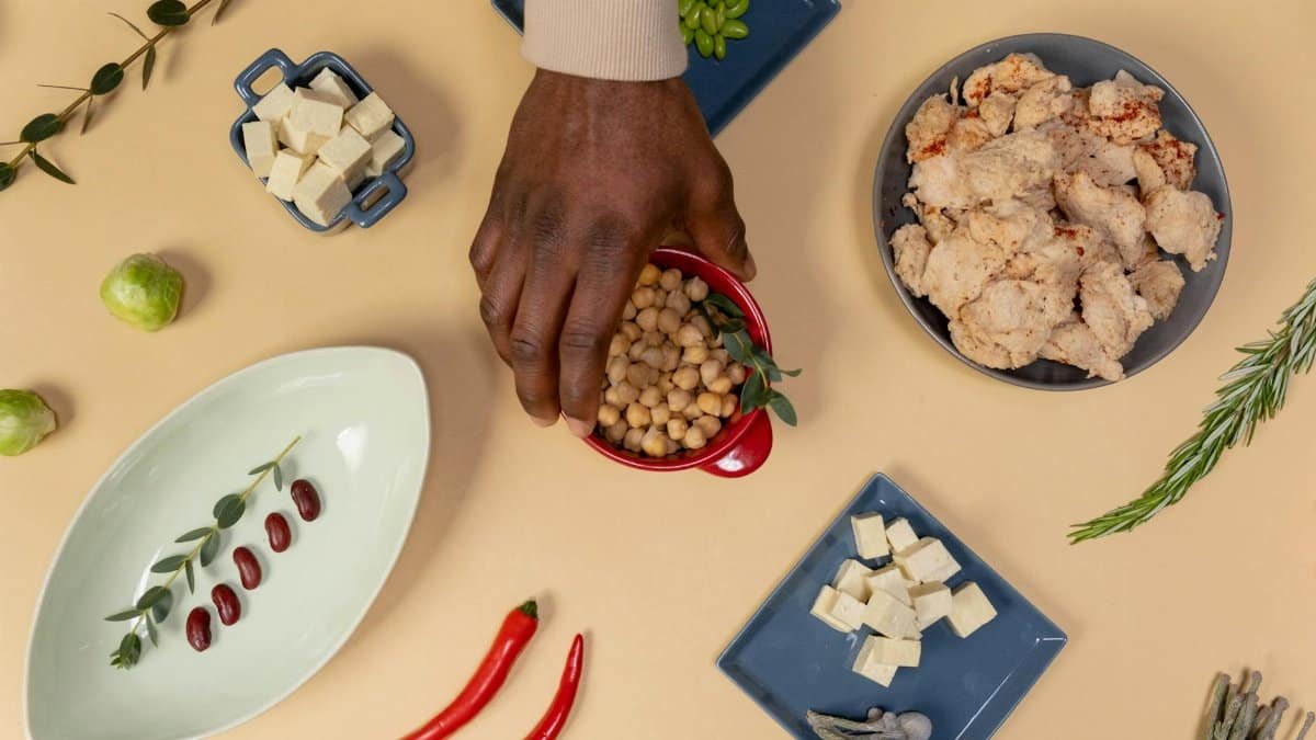 Vibrant flat lay of various vegan ingredients, including chickpeas, tofu, and herbs.