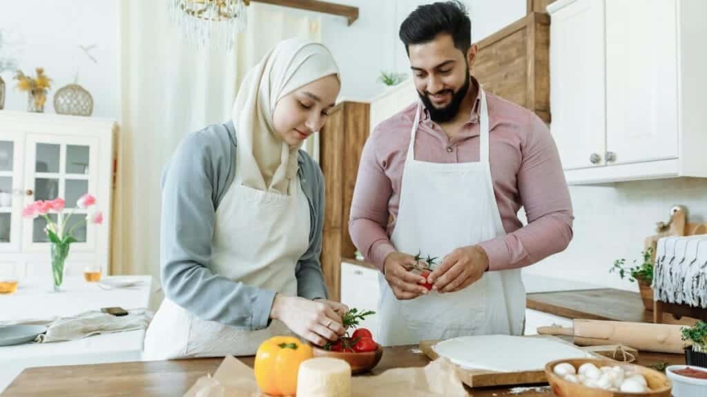 A couple prepares food together in a modern kitchen, showcasing love and partnership.