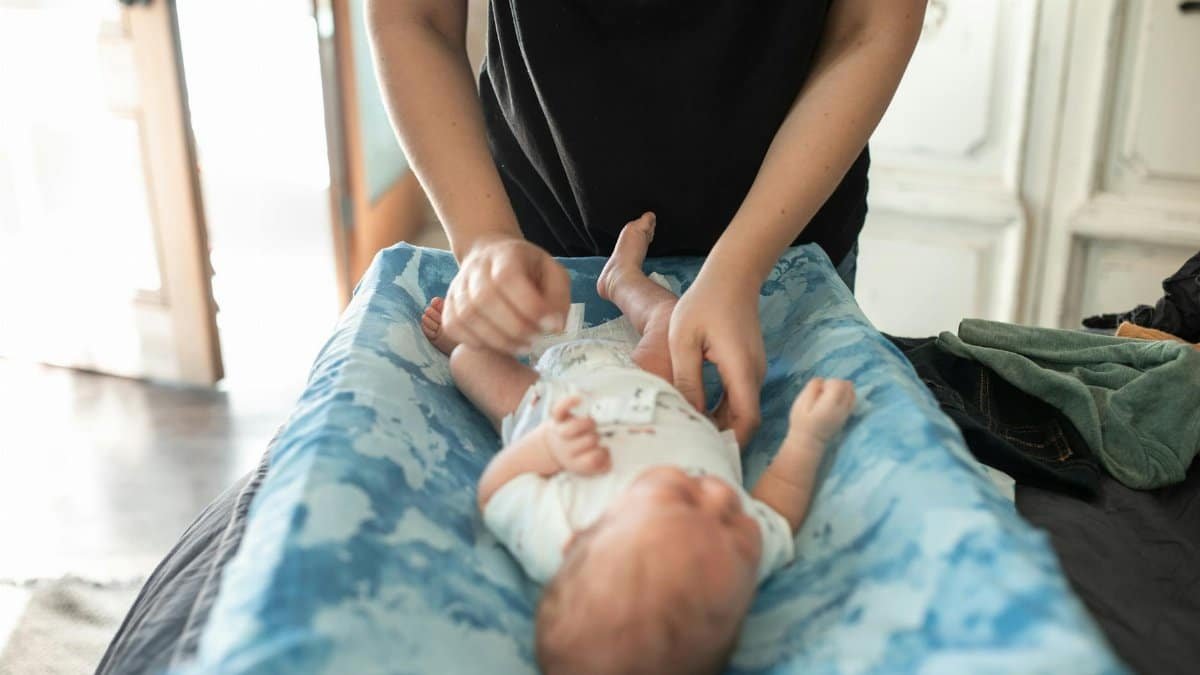 Gentle care of a newborn baby on changing table in cozy home setting.