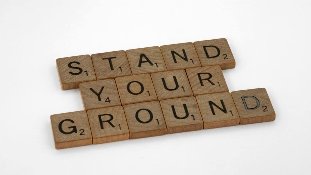 Scrabble tiles spelling "Stand Your Ground" on a white background.