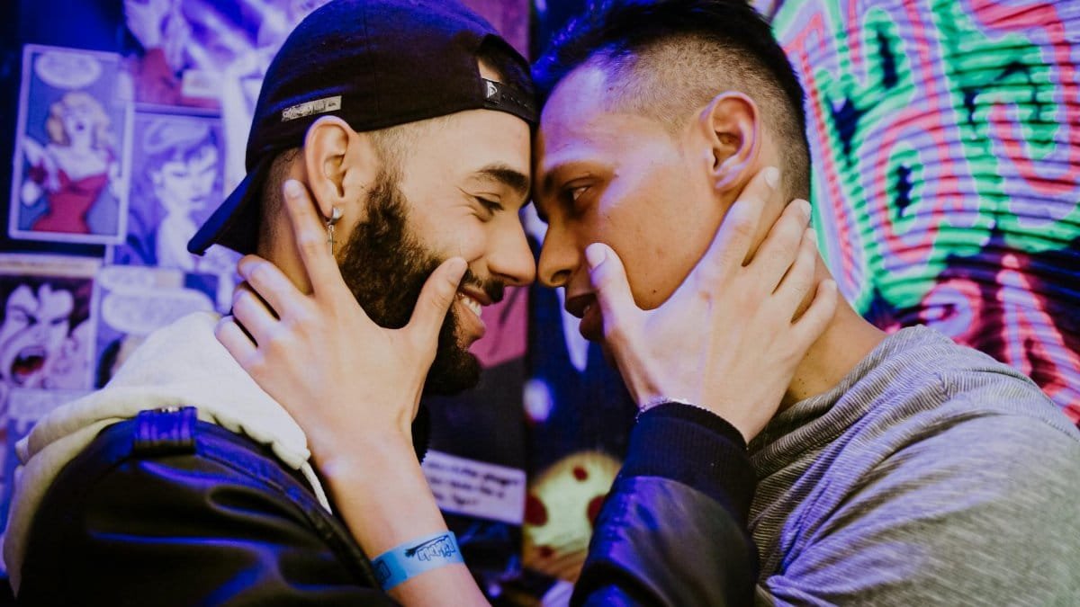 Two men share a close and affectionate moment in the vibrant streets of São Paulo.