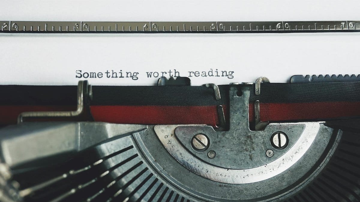 Close-up of a vintage typewriter with the phrase 'Something worth reading'.