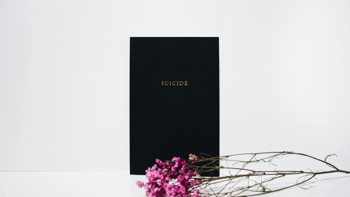 Minimalist art highlighting suicide awareness with flowers on a white background.