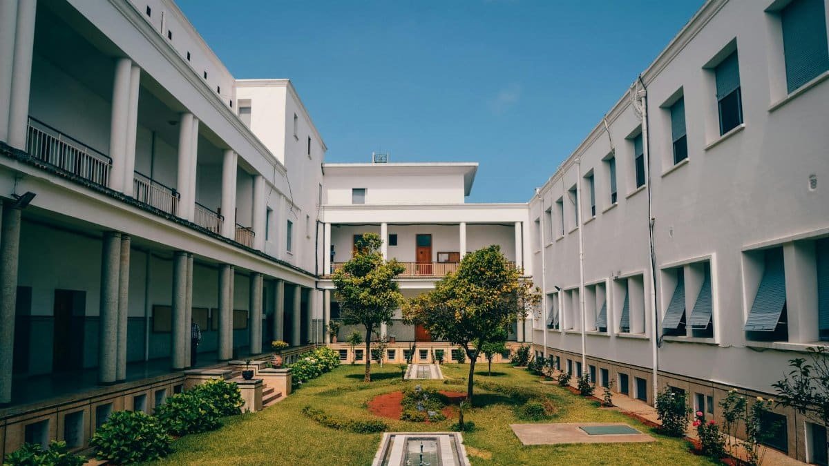 Elegant university building with garden courtyard in Rabat, Morocco under clear blue sky.