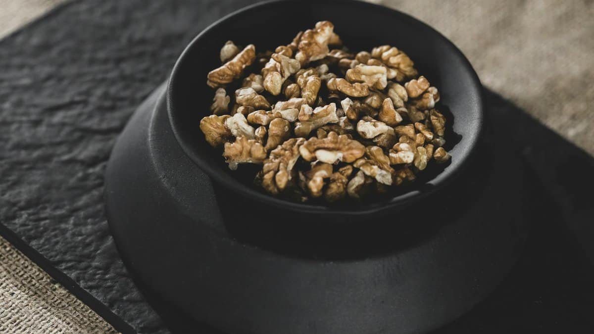 Nutritious organic walnuts in a black bowl, perfect for healthy snacks or raw diets.