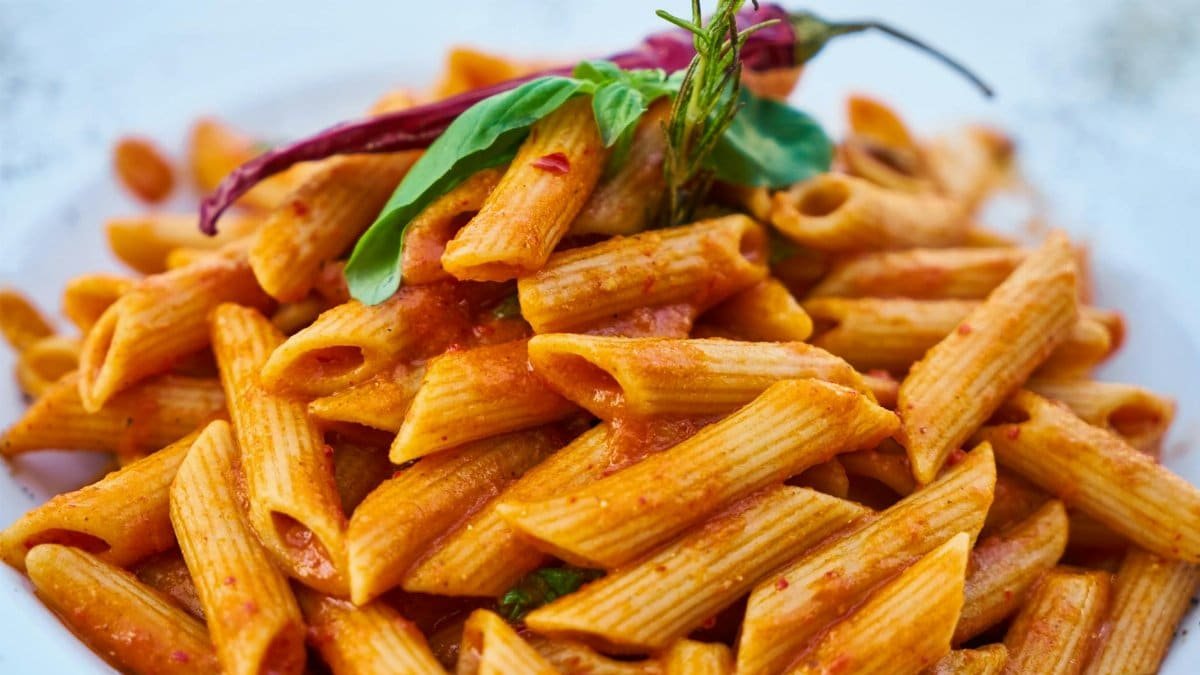 Savor the flavors of Italian cuisine with this close-up photo of tasty penne pasta in tomato sauce.