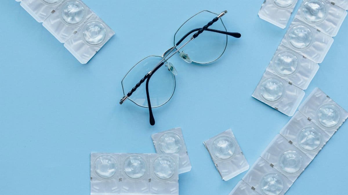 Eyeglasses and contact lenses on a blue background. Concept of eye care and vision correction.